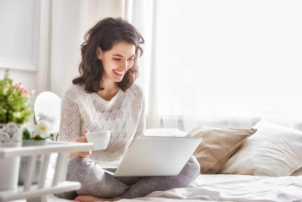 woman sitting on couch and looking at her laptop