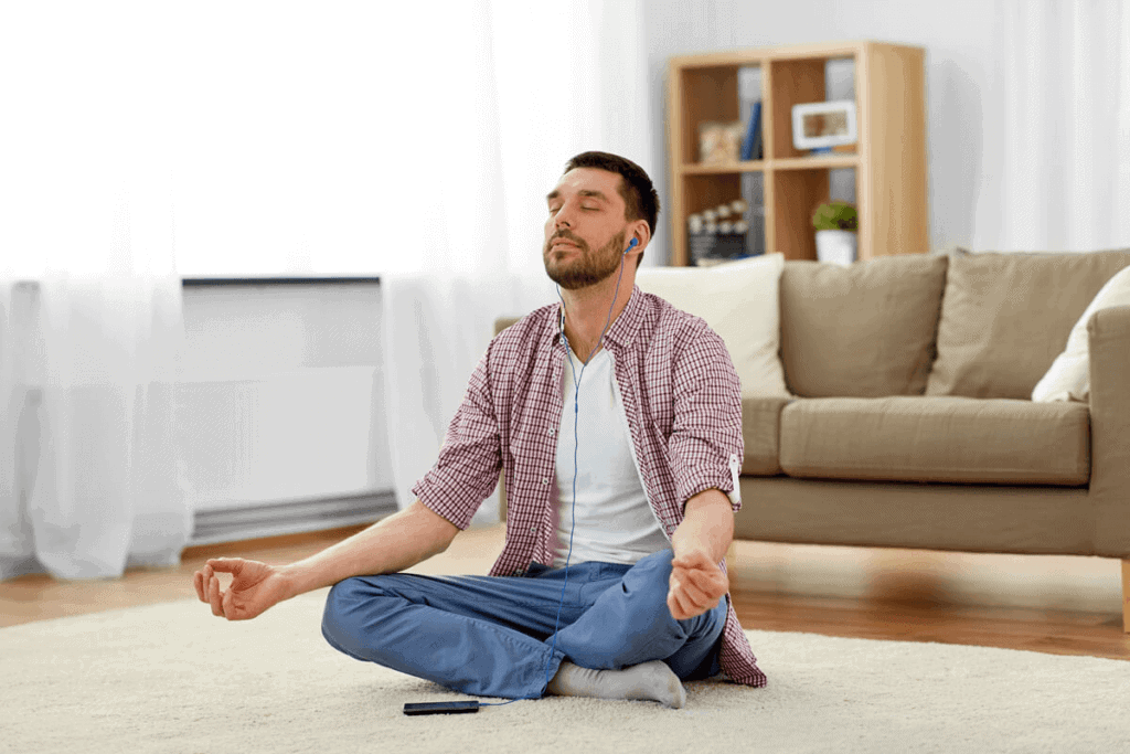 man sitting in his home meditating with headphones