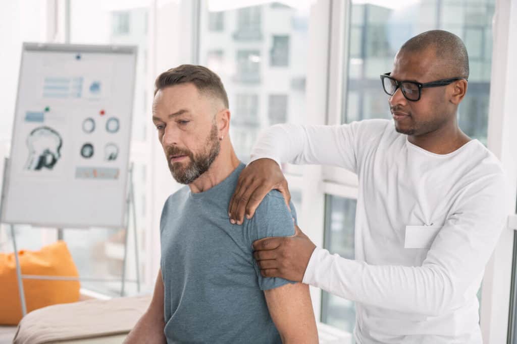 practitioner checking patients shoulder