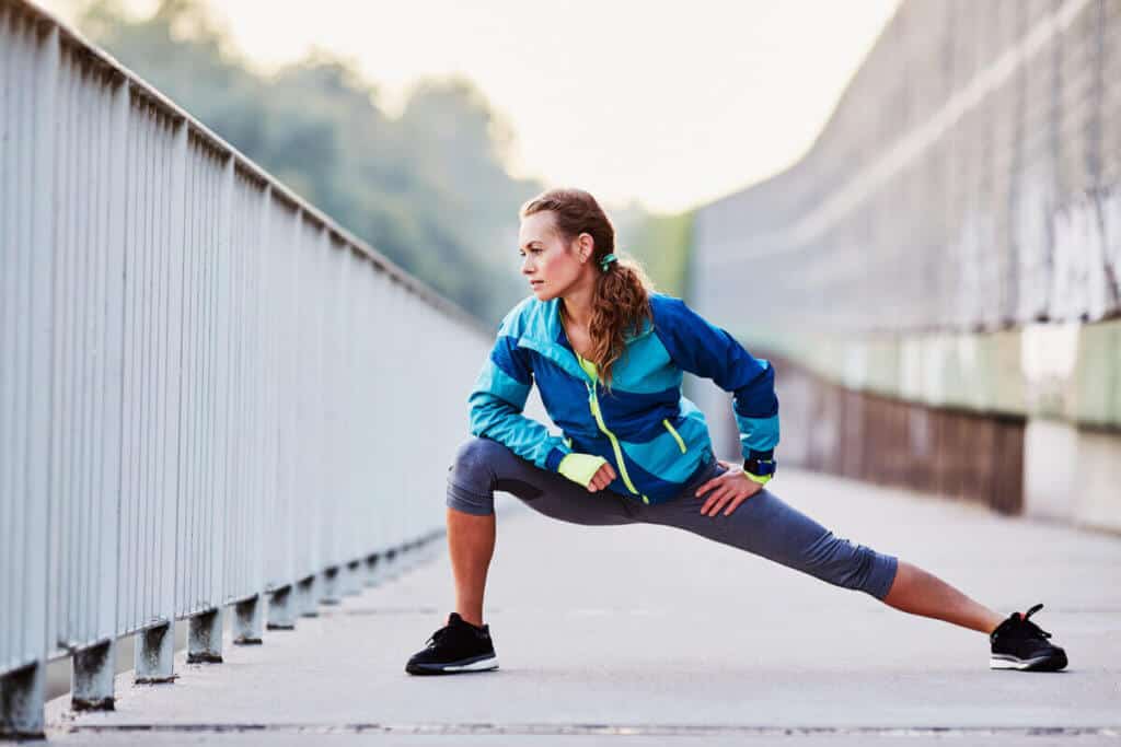 woman stretching outside before workout