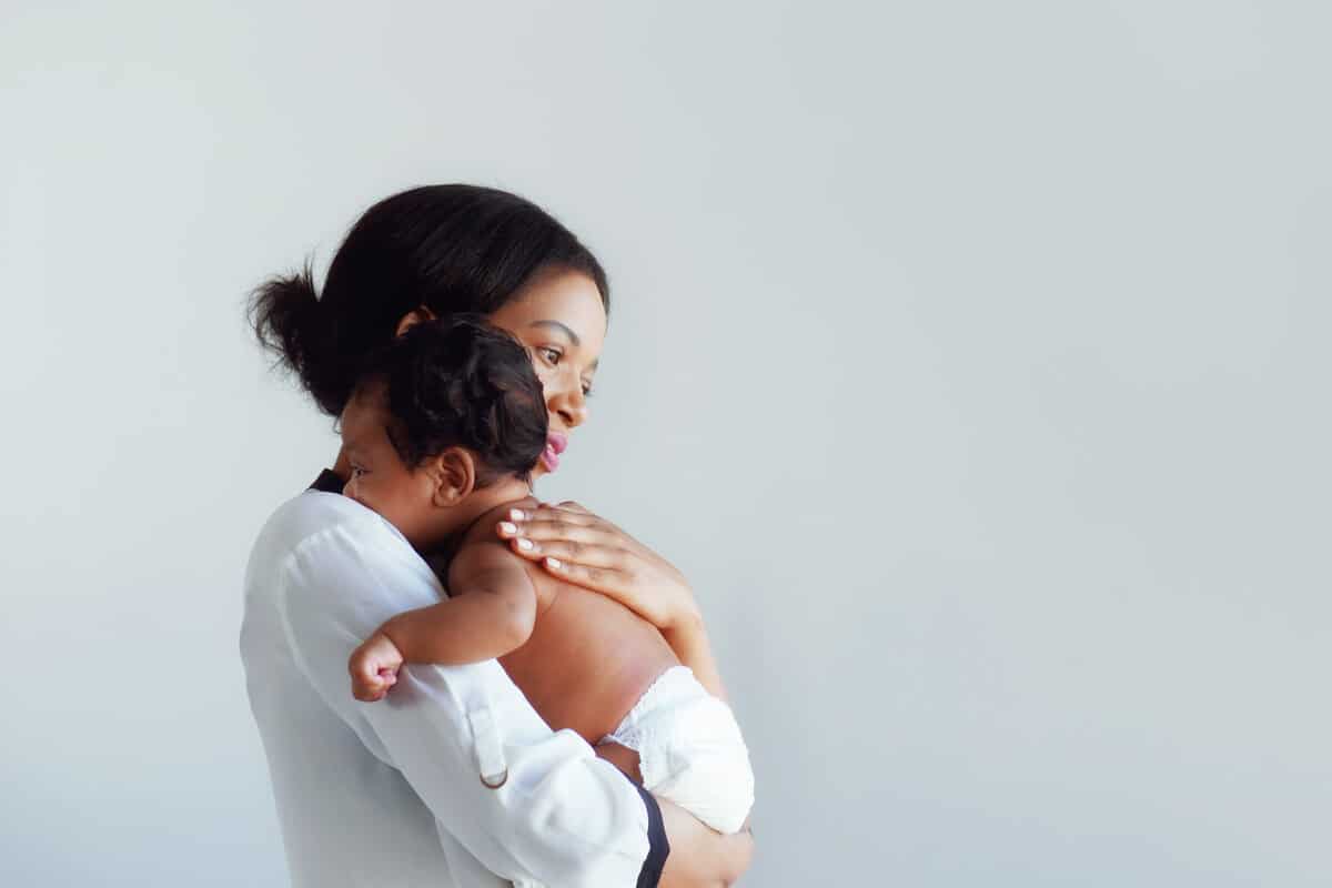 woman holding her baby in her arms while standing up