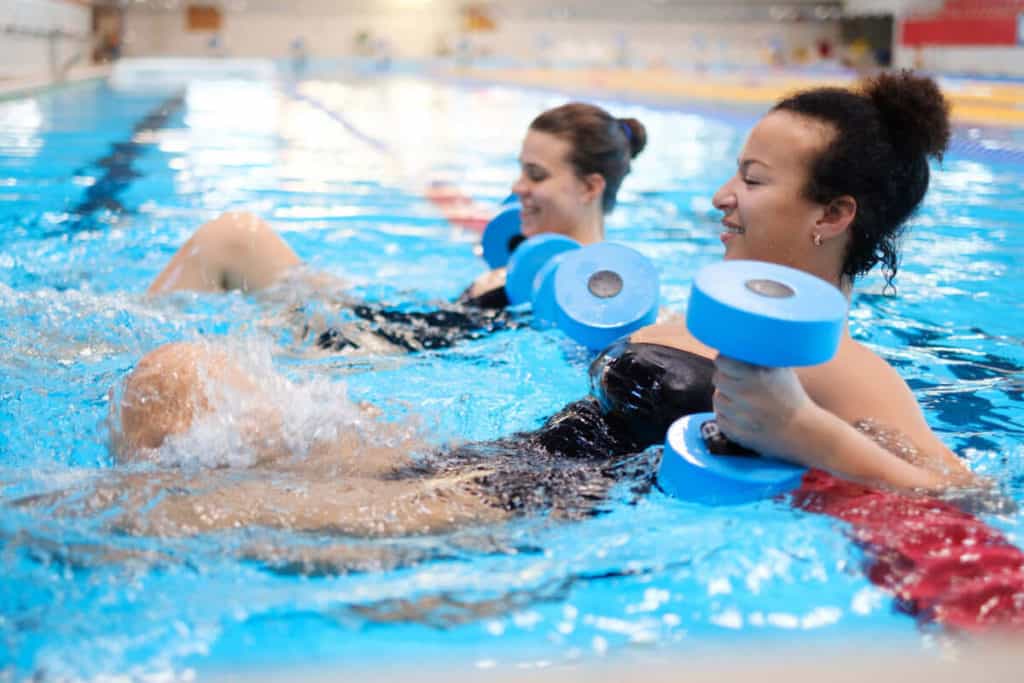 two women doing aquacise in large indoor pool