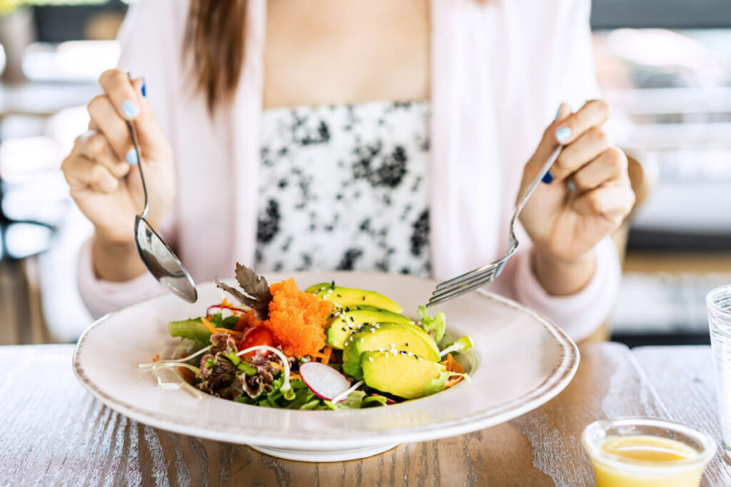 person eating a salad bowl