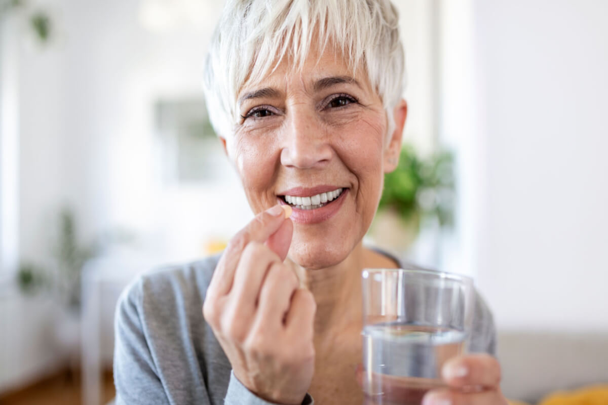 postbiotics woman taking postbiotic supplement