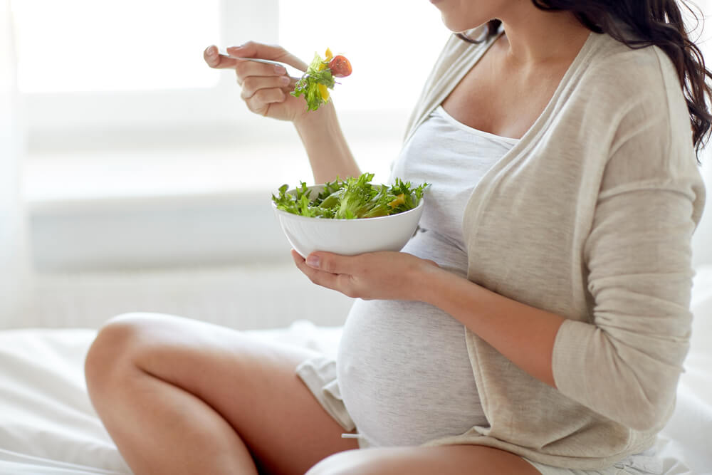 pregnant woman eating a salad