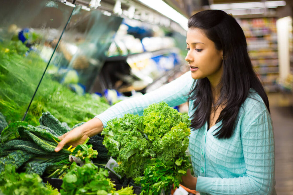 woman shopping for green leaf vegetables