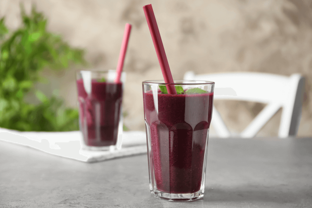 two acai smoothies on a table with straws