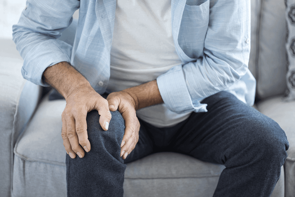 close up of person holding their knee in pain