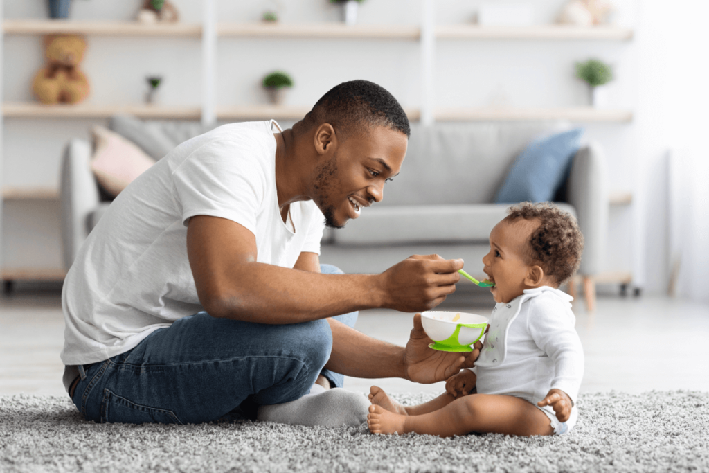 father feeding an infant