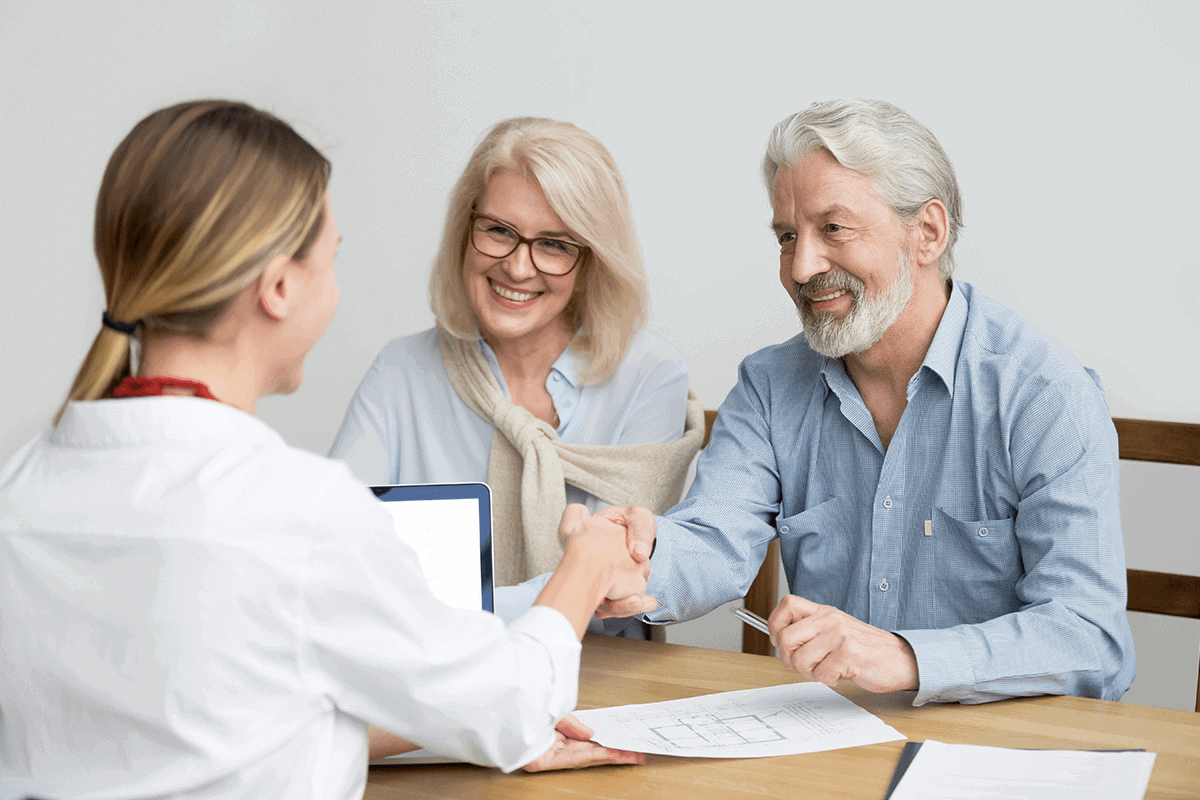 practitioner sitting with a couple and shaking the man's hand